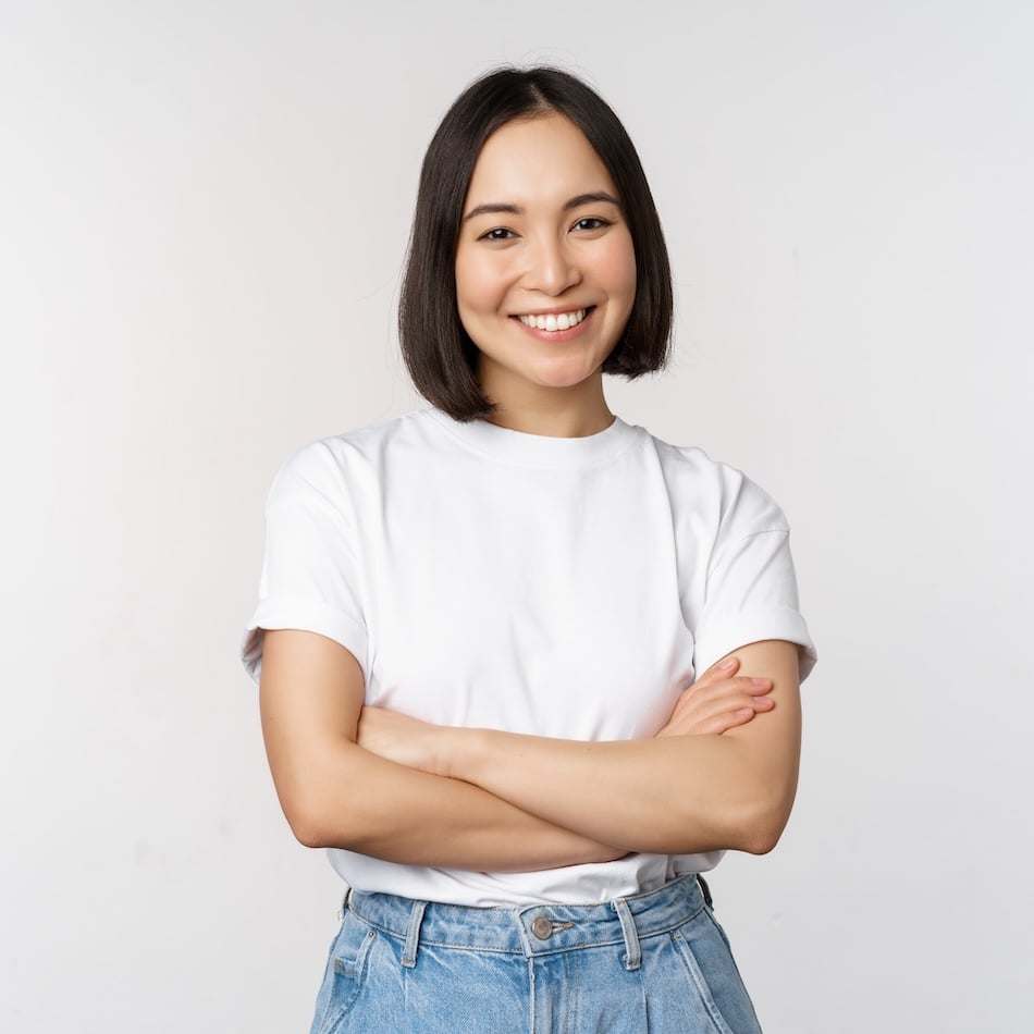 portrait happy asian woman smiling posing confident cross arms chest standing against studio background
