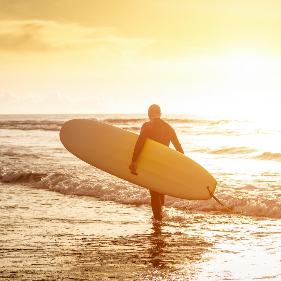 man with surfboard on beach